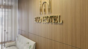 A hotel sign with the name 'ECO HOTEL' in gold letters on a wooden wall. - Eco Hotel (Mokpo)