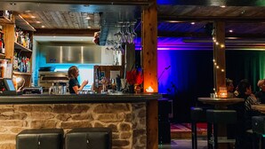 Ein Restaurant mit Barbereich, Steinwänden und Holzboden.