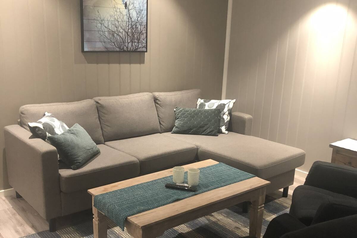 Een moderne woonkamer met een modulaire bank, een salontafel en een bijzettafeltje.