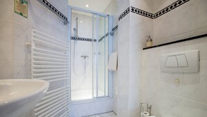 A bathroom with a white sink, a shower with a glass door, and a toilet. - Hotel Wegener (Mannheim)