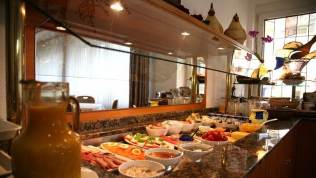 A buffet with various dishes and a pitcher of sauce. - Hotel Wegener (Mannheim)