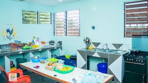 A kitchen with a stove, sink, and various food items on the counter.