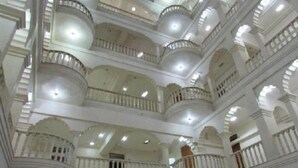 A multi-level interior with balconies and a central open space. - Iroomz Shanbhag Towers International (Hospet)