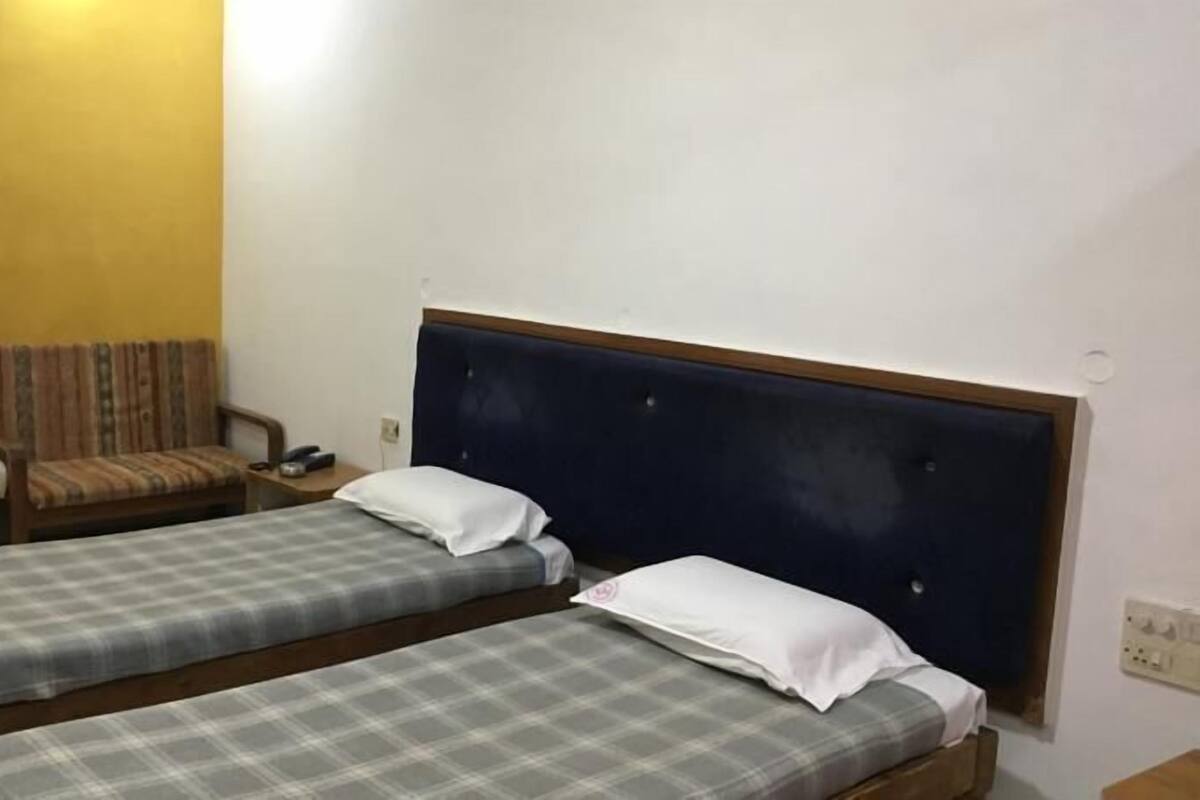 A room with two single beds, a sofa, and a small table.