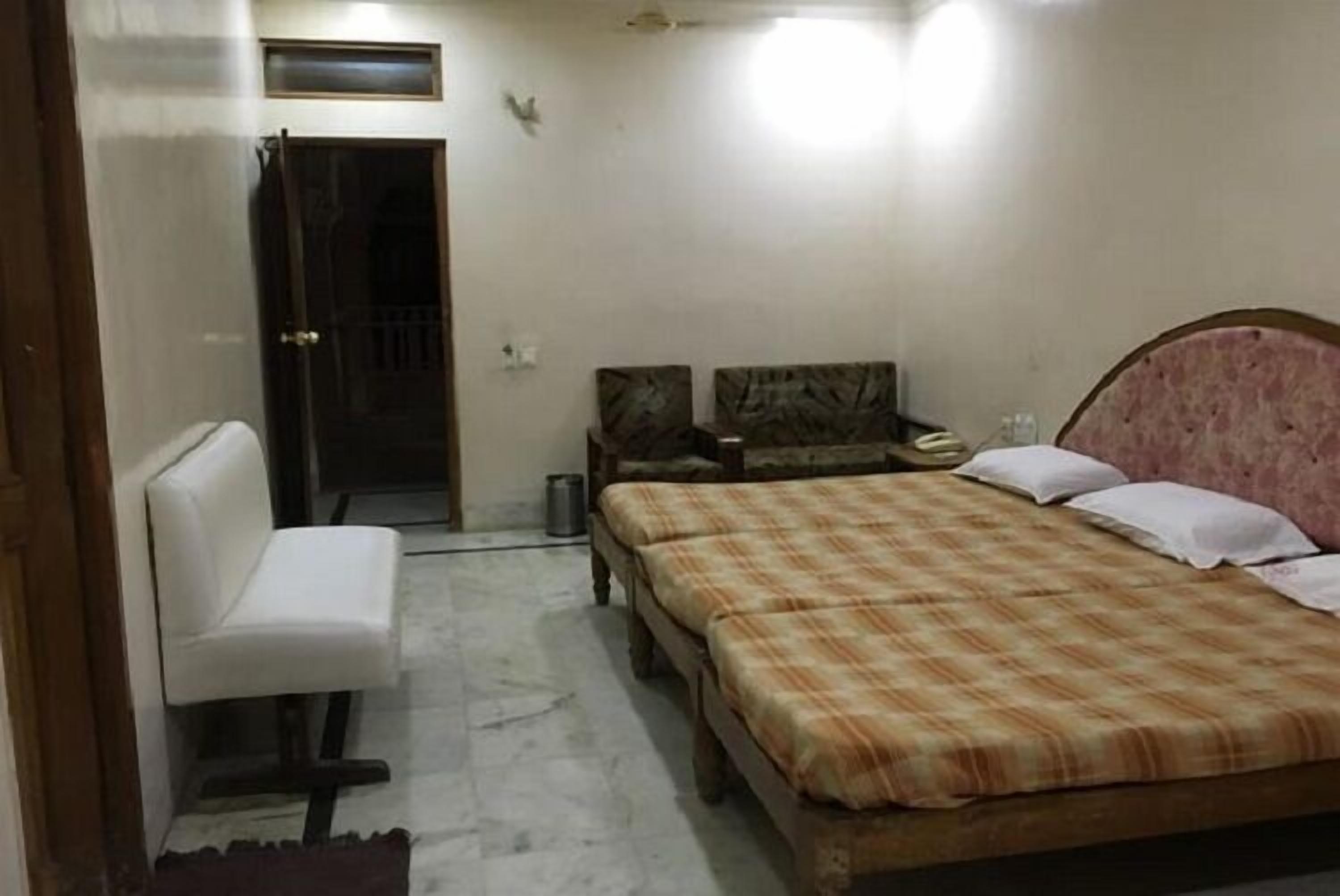 Un dormitorio con cama, una silla y un armario.