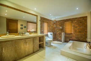A bathroom with a large sink, a bathtub, and a shower.