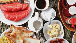 Un assortiment de plats et de boissons pour le petit-déjeuner, disposés sur une table.