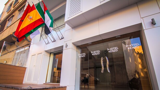 A hotel entrance with flags, a modern facade, and glass doors. - Hotel Kenzo (Safi)
