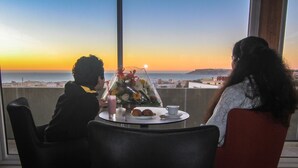 A dining table with a view of the ocean at sunset. - Hotel Kenzo (Safi)