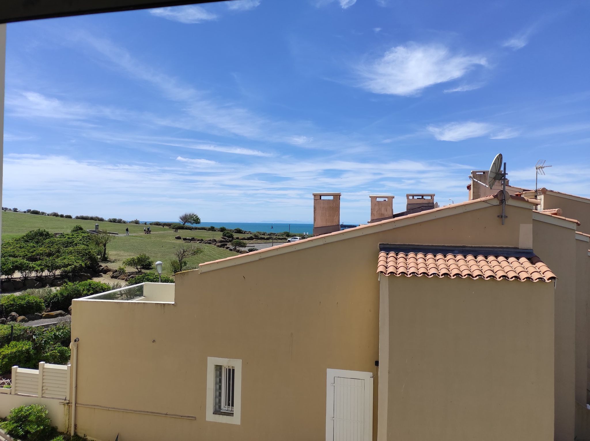 Ein Wohngebäude mit flachem Dach, Satellitenschüssel und einem kleinen Fenster.