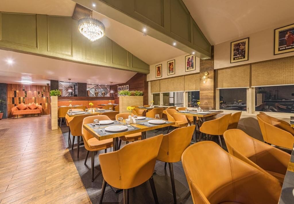Ein Restaurant mit Holzböden, orangefarbenen Stühlen und gedeckten Tischen.