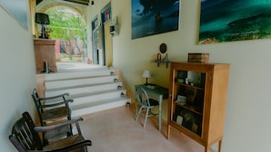 A staircase leading to a second floor with a desk and chair, a cabinet with glass doors, and two framed pictures on the wall. - Casa Mespilea Guest House (Paphos)