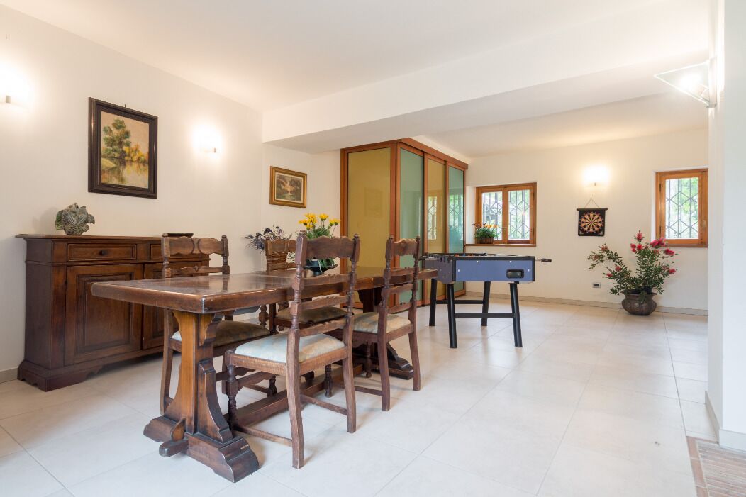A dining area with wooden furniture, a foosball table, and decorative items.