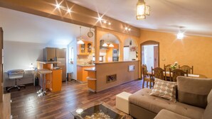 A modern living room with a sofa, a glass coffee table, and a kitchen area with a bar. - Cozy family-friendly fenced villa, pool and outdoor jacuzzi (Karojba)