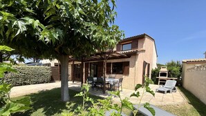 A house with a patio, a table, and chairs. - corner house for 7 persons, 4 bedrooms, in TAMARIS, WIFI, 500m from the sea in Portiragnes plage (PORTIRAGNES)