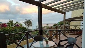 Un espace extérieur abrité, avec une table et des chaises, offrant une vue panoramique.