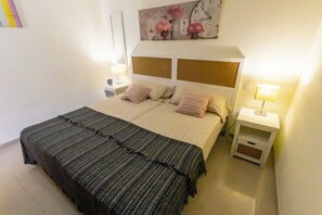 Una camera da letto ordinata con un letto, due comodini e una sveglia a parete.