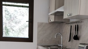 A compact kitchen with a built-in washing machine, a toaster, and a window with a view of trees. - Independent studio in villa overlooking Monaco + parking in Monaco (beausoleil)