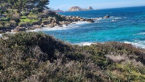 Un paysage côtier caractérisé par des rivages rocheux, une végétation luxuriante et une mer d’un bleu limpide.