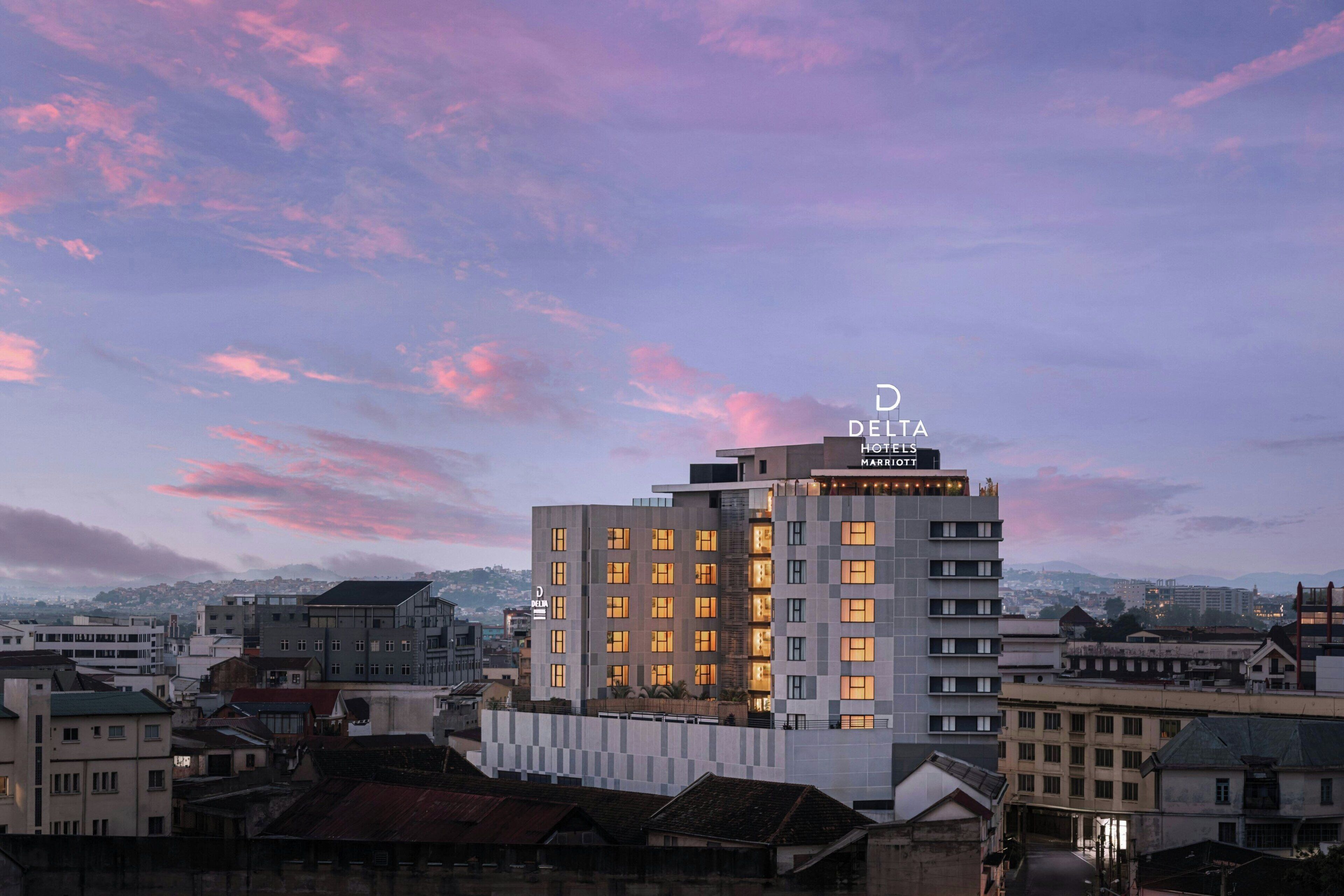 A hotel with a modern design, multiple floors, and a prominent sign at the top.