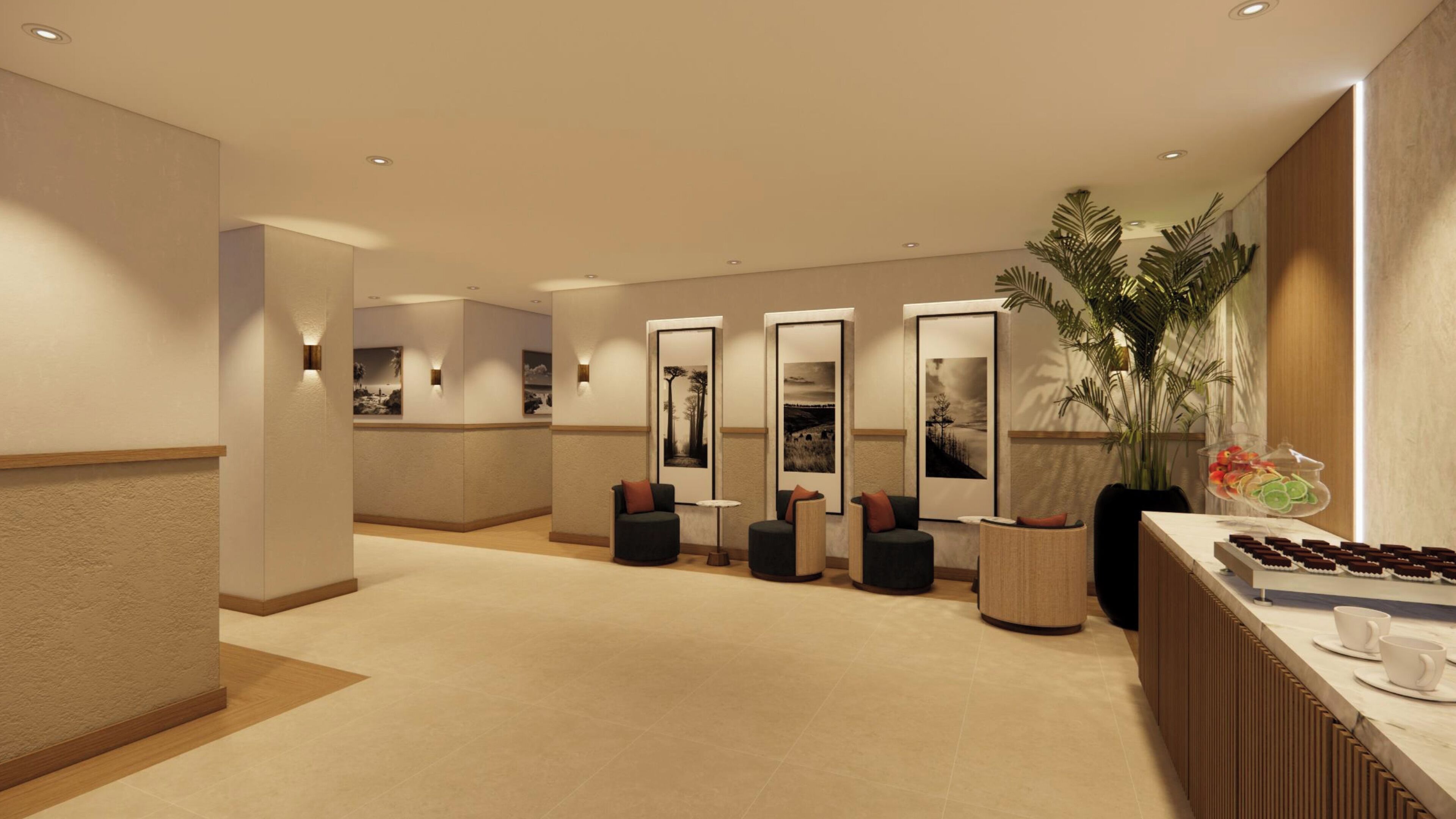 A modern hotel lobby with a reception desk, seating area, and framed artwork on the walls.
