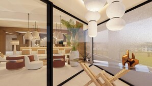 Um interior moderno com divisória de vidro, mobiliário contemporâneo e iluminação pendente.