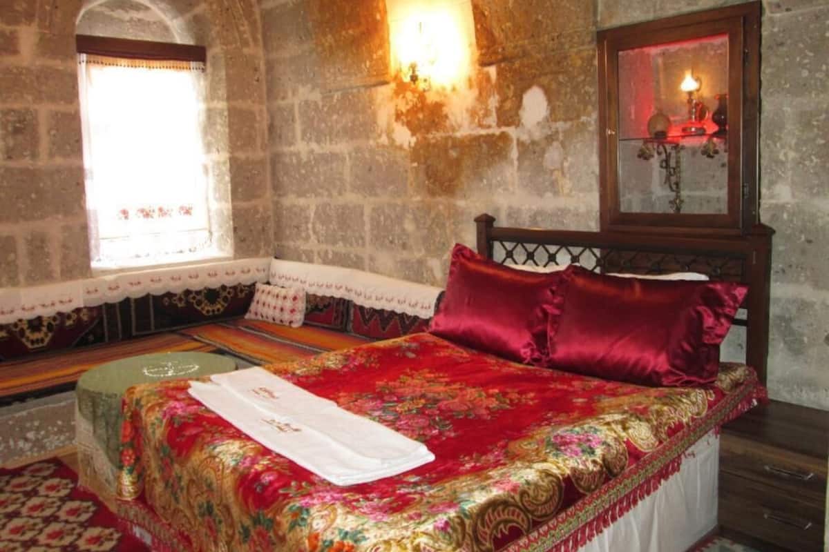 Una habitación con cama, ventana, luz empotrada y espejo.