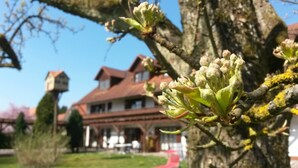 A building with a traditional architectural style, featuring a prominent red roof and a symmetrical facade. - Pension Aufeld (Landsberg am Lech)