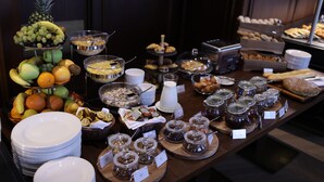 Un bufé con diversos alimentos, como frutas, pasteles y salsas.