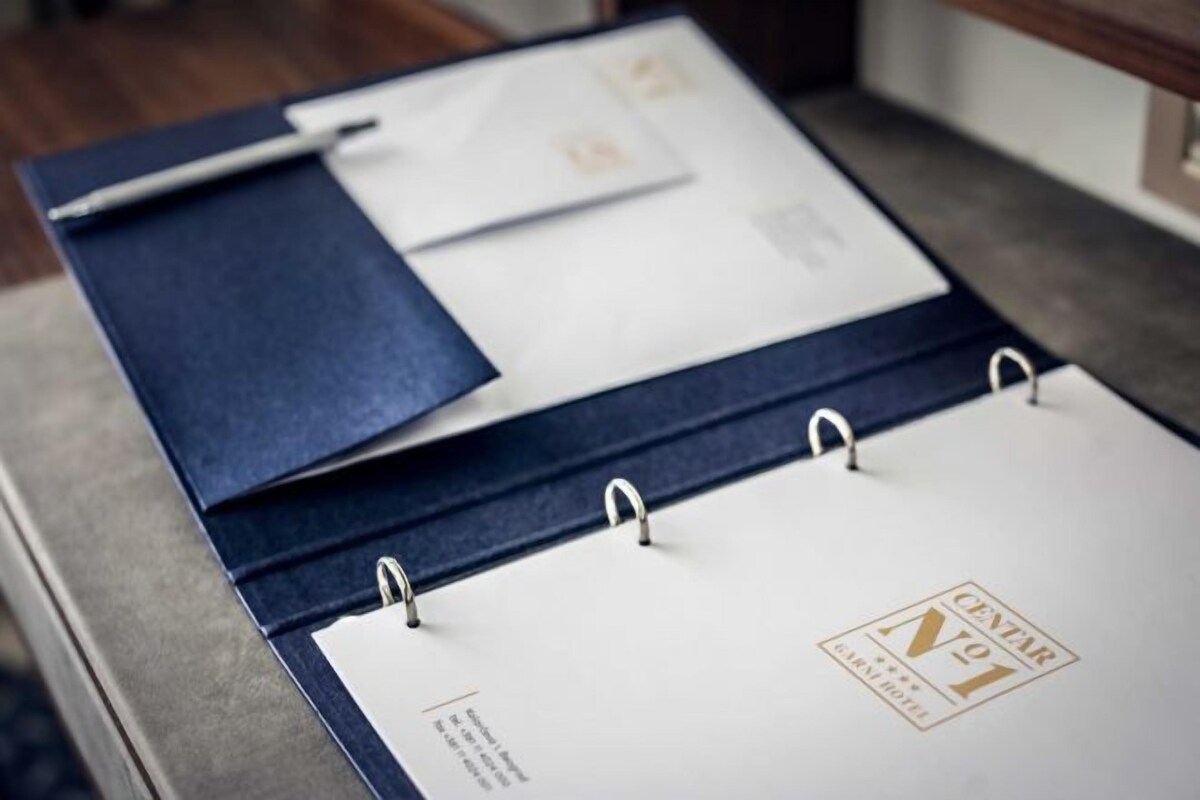 A planner with a pen and an envelope on a desk.