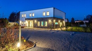 A modern two-story building with a flat roof, large windows, and a stone facade. - ManavaHotel (Herstal)
