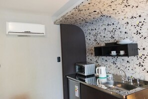Departamento junior, 1 cama King size | Cocineta privada | Refrigerador, horno, parrilla de estufa y tetera eléctrica 