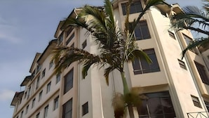 Ein mehrstöckiges Gebäude mit moderner Architektur, das eine Reihe von Fenstern und Balkonen zeigt.