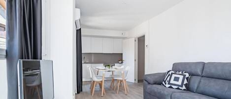 Una sala de estar moderna con un sofá gris y un televisor de pantalla plana.