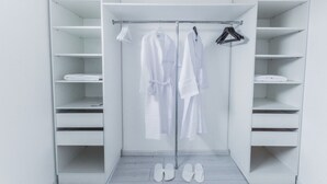 Un vestidor amplio con varios estantes y espacio para colgar.