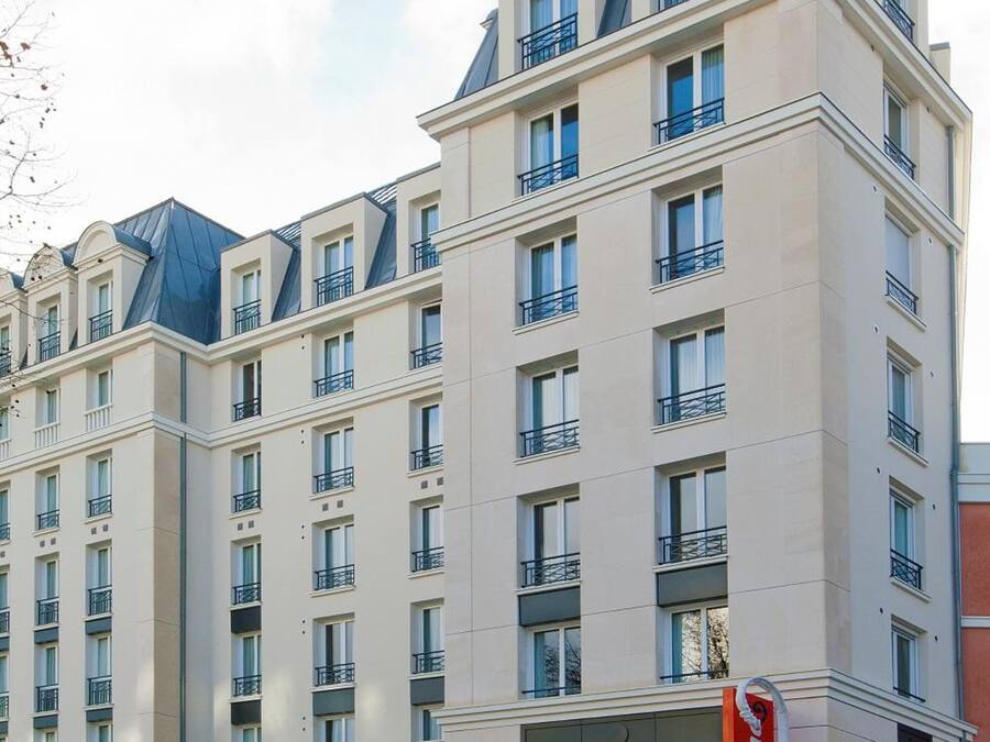 Un hotel de varios pisos con un diseño moderno, que cuenta con balcones y ventanas amplias.