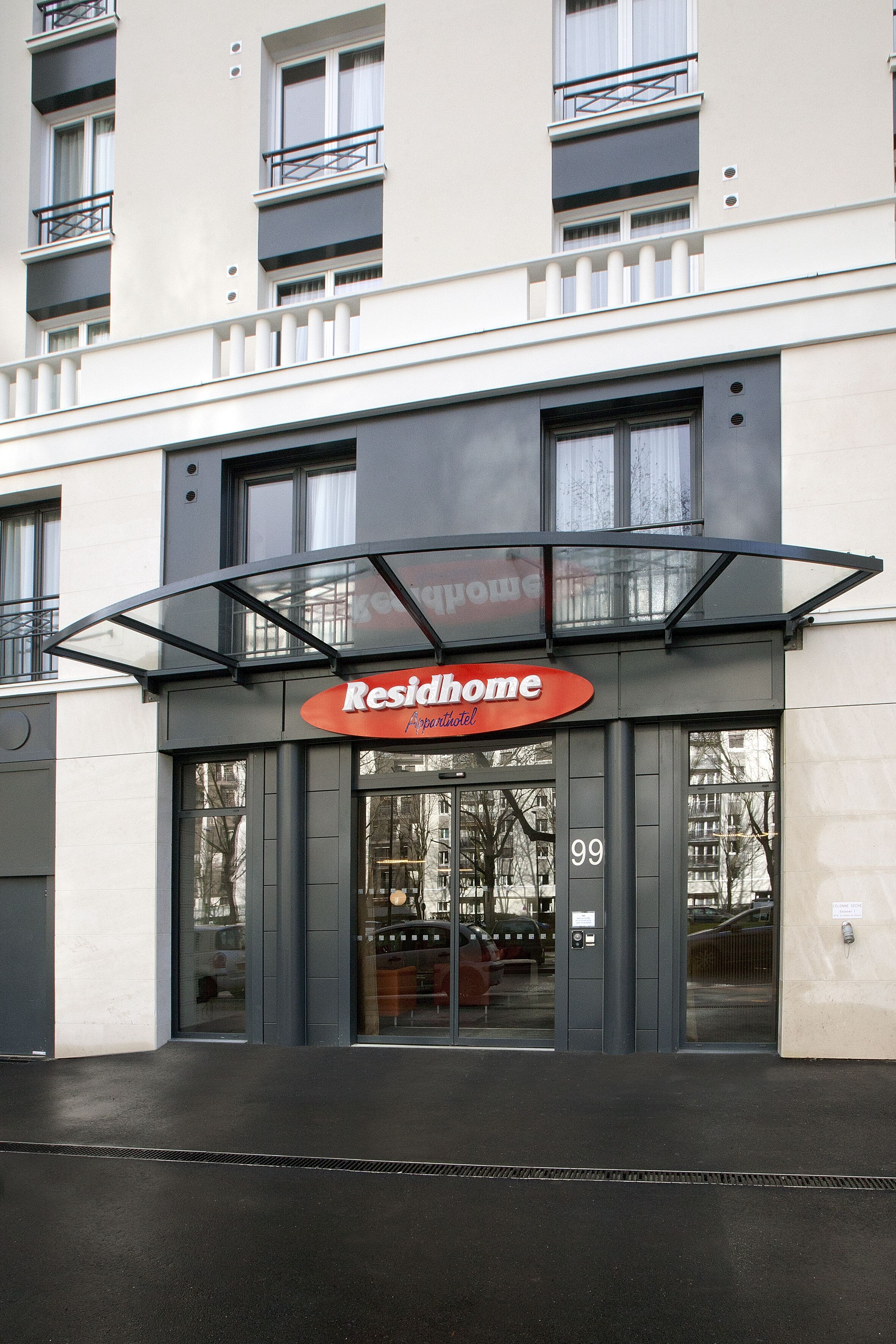 A building with a sign reading "Residhome Apartment Hotel" and the number 99.