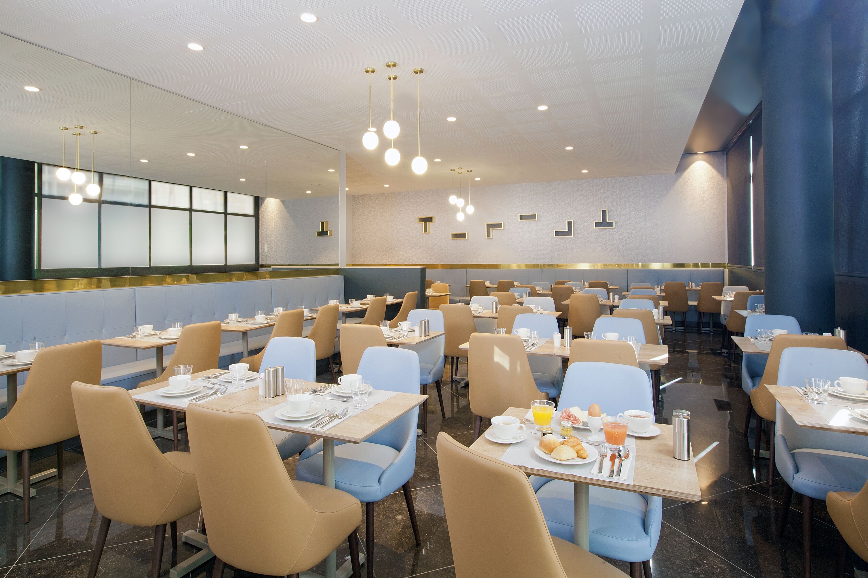 A spacious dining area with multiple tables and chairs, equipped with basic dining essentials like plates, cups, and cutlery.