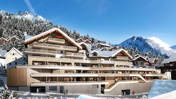 Un hôtel à plusieurs étages doté de balcons, d’une architecture en bois et, en arrière-plan, d’une piste de ski.