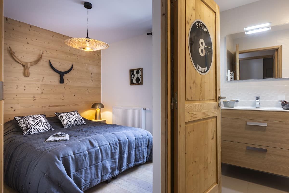 Une chambre à coucher avec un lit, une lampe de chevet et une tête de lit en bois.