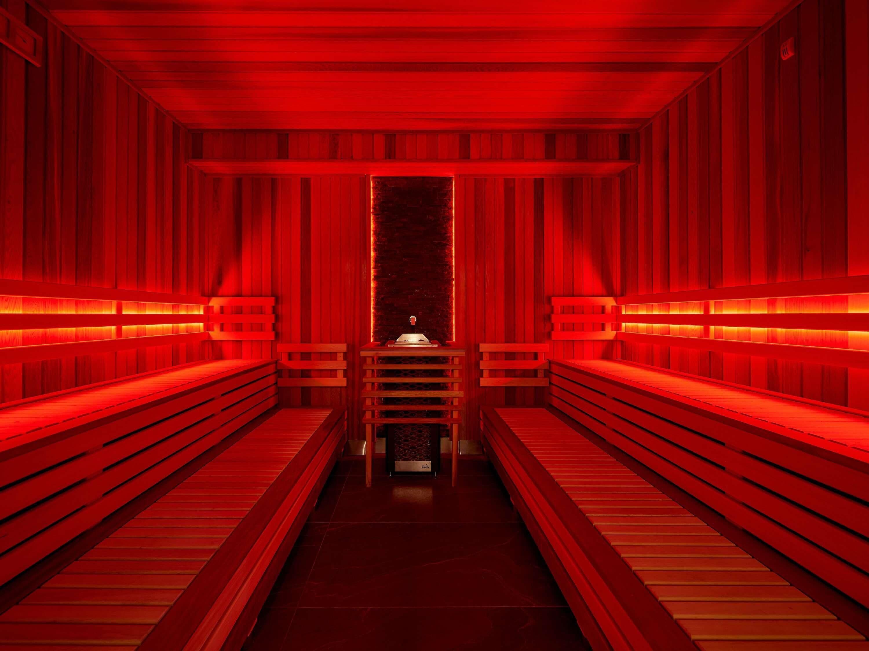 A sauna with wooden benches and a central bench.
