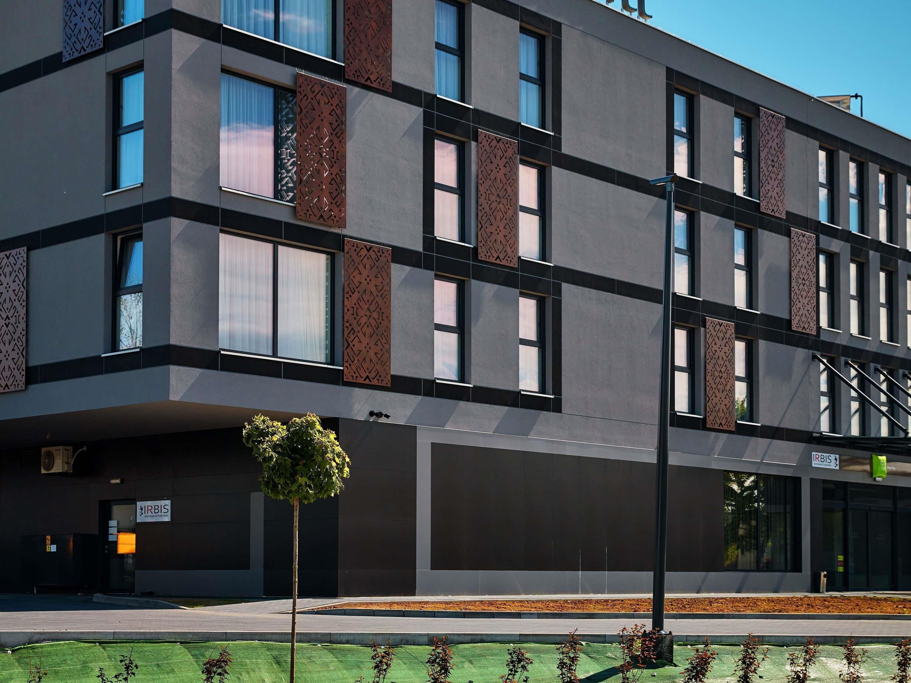 A modern building with a flat facade, large windows, and a sign for 'IRBIS.'