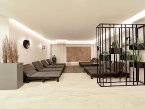 A modern lounge area with multiple seating options, a decorative wall, and indoor plants. - ibis Styles Nowy Targ (Nowy Targ)