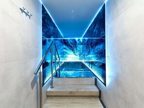 A modern staircase with a glass barrier, leading to a lower level. - ibis Styles Nowy Targ (Nowy Targ)
