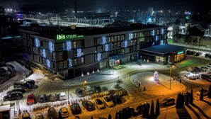 A modern hotel with a prominent 'ibis styles' sign, multiple parking spaces, and a snow-covered parking lot. - ibis Styles Nowy Targ (Nowy Targ)
