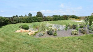 A well-maintained garden with a variety of plants and a stone pathway. - Chambres d'hôtes de l'Orval (Thiergeville)