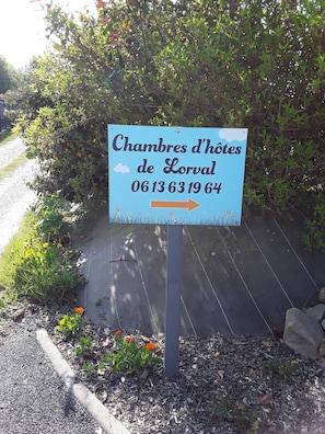 Señal para 'Chambres d'hôtes de Lorval' con un número de contacto.