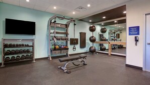 A gym with exercise equipment, dumbbells, and a mirror. - Tru by Hilton Grand Prairie (Grand Prairie)