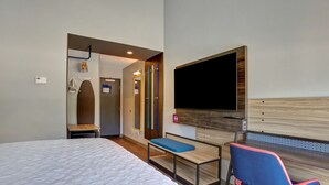 A hotel room with a large bed, a desk with a chair, a flat-screen TV, and a wooden headboard. - Tru by Hilton Grand Prairie (Grand Prairie)