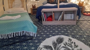 A tented accommodation with two beds, a bookshelf, and a decorative wall. - Le Clos des Epinettes (Angé)